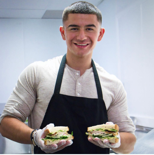 cook holding sandwiches
